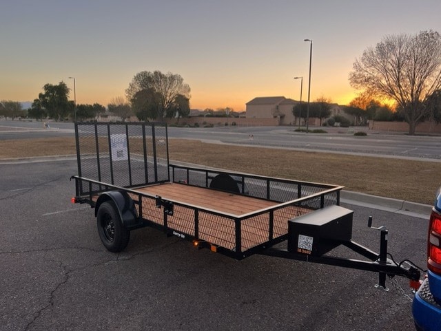 Carry On 6.3'×12' utility trailer — wood deck open at sunset